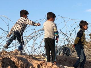 Kinder mit Stacheldraht in Kara Tepe